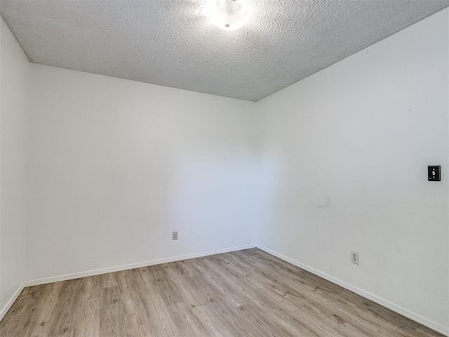 2416 Ellis Dr, Shawnee, OK 74804 - empty room with light wood-style flooring, a textured ceiling, and baseboards