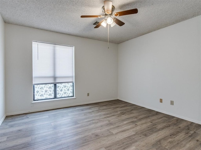 2416 Ellis Dr, Shawnee, OK 74804 - unfurnished room with baseboards, a textured ceiling, wood finished floors, and ceiling fan