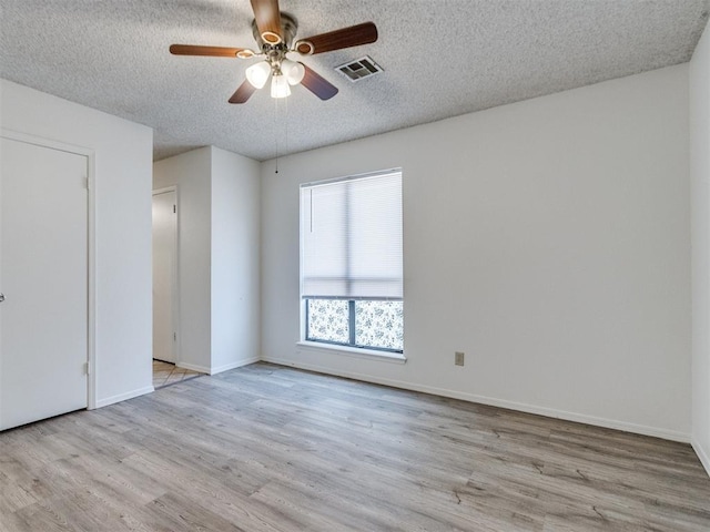 2416 Ellis Dr, Shawnee, OK 74804 - spare room with visible vents, a textured ceiling, a ceiling fan, and wood finished floors