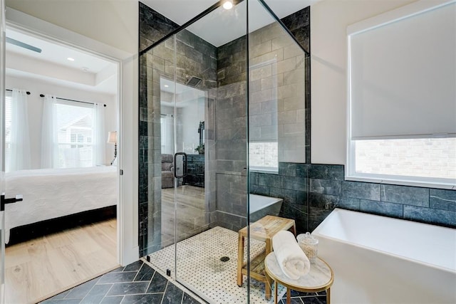 full bathroom featuring a shower stall, a bathtub, and ensuite bathroom