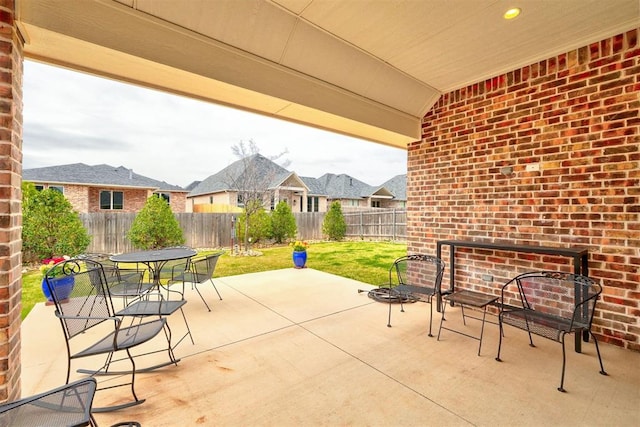 view of patio / terrace with a fenced backyard, a residential view, and outdoor dining area