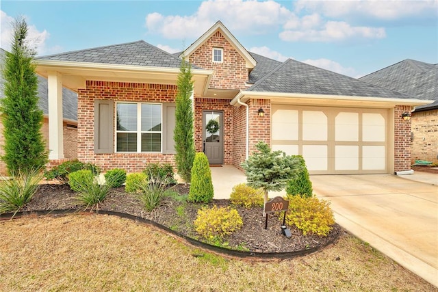 view of front of home featuring concrete driveway, an attached garage, and brick siding