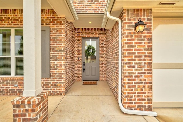 property entrance with brick siding and visible vents