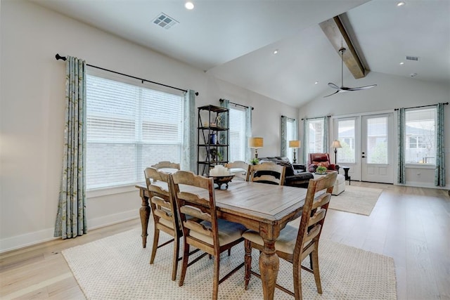 dining room with light wood-style flooring, a healthy amount of sunlight, lofted ceiling with beams, and visible vents