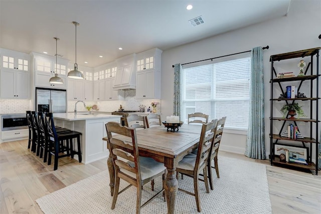 dining space featuring baseboards, light wood finished floors, visible vents, and recessed lighting