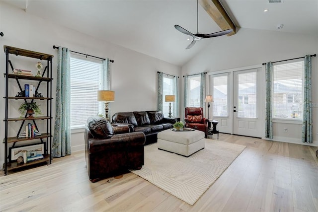 living room with light wood-type flooring, a wealth of natural light, a ceiling fan, and vaulted ceiling with beams