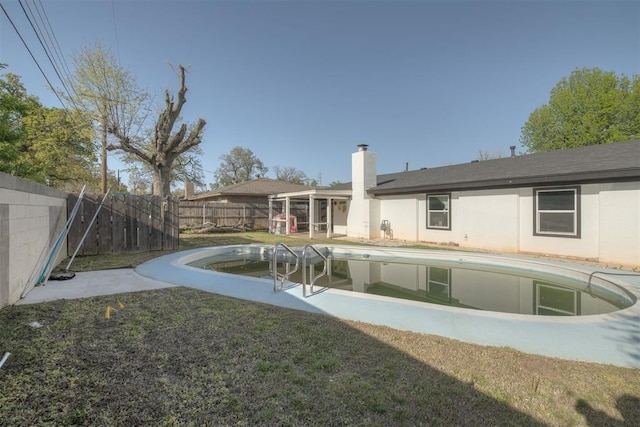 back of property with a sunroom, a fenced backyard, a lawn, a chimney, and a fenced in pool