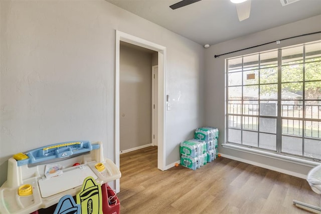 playroom with wood finished floors, ceiling fan, and baseboards