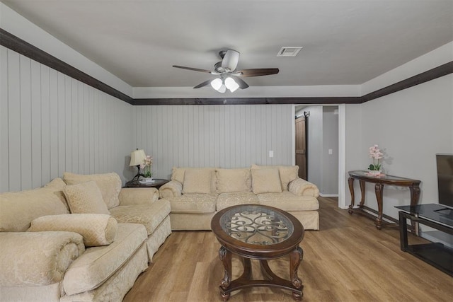 living room with visible vents, ceiling fan, and light wood finished floors