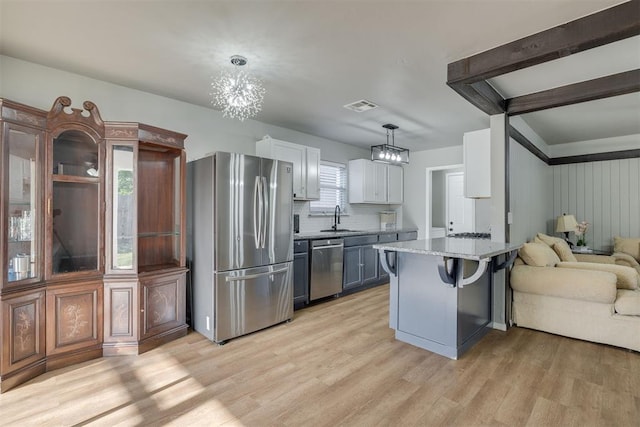 kitchen with a chandelier, light wood-style floors, visible vents, appliances with stainless steel finishes, and a sink