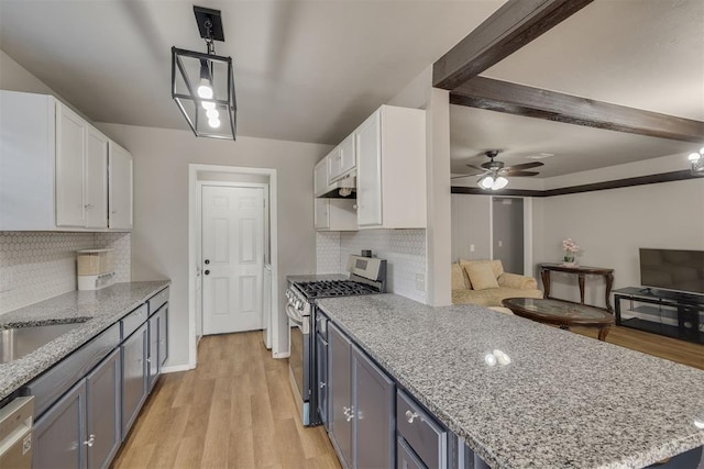 kitchen with stainless steel appliances, light stone countertops, and white cabinets