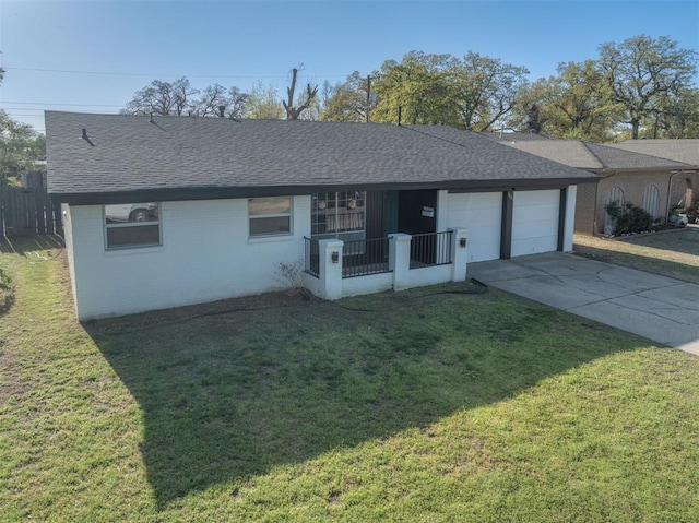 ranch-style house featuring driveway, an attached garage, a shingled roof, and a front lawn