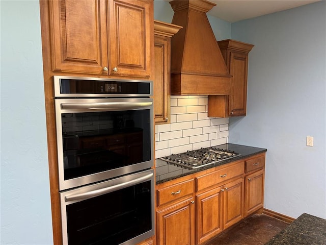 1595 County Road 1240, Tuttle, OK 73089 - kitchen with stainless steel appliances, premium range hood, brown cabinetry, and decorative backsplash