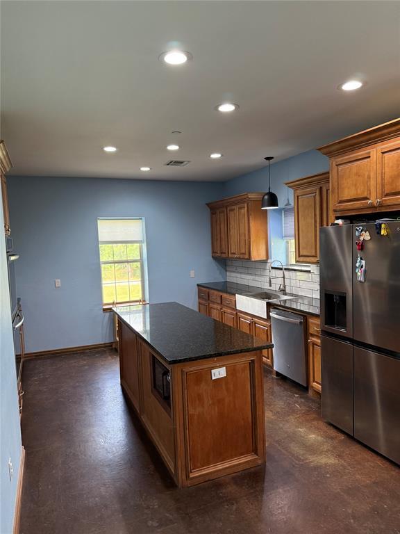 1595 County Road 1240, Tuttle, OK 73089 - kitchen with stainless steel appliances, brown cabinetry, decorative backsplash, recessed lighting, and a kitchen island