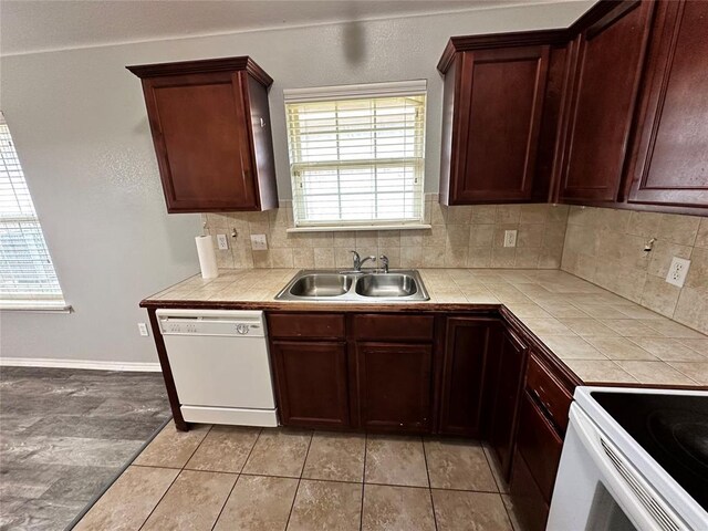 12308 SW 9th Ter, Yukon, OK 73099 - kitchen featuring white dishwasher, a sink, tile counters, tasteful backsplash, and light tile patterned floors