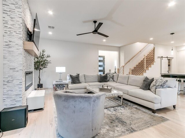 3532 Paso Robles Ter, Edmond, OK 73034 - living area with ceiling fan, light wood-style flooring, visible vents, stairway, and a tile fireplace