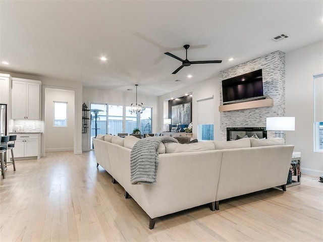 3532 Paso Robles Ter, Edmond, OK 73034 - living room with a large fireplace, recessed lighting, light wood-style floors, and ceiling fan with notable chandelier