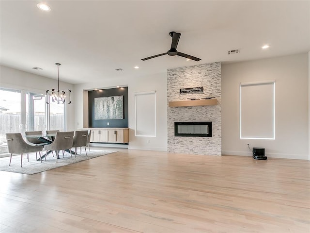 3532 Paso Robles Ter, Edmond, OK 73034 - unfurnished living room with recessed lighting, a fireplace, light wood-style flooring, visible vents, and ceiling fan with notable chandelier
