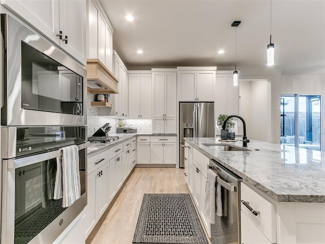 3532 Paso Robles Ter, Edmond, OK 73034 - kitchen with white cabinetry, appliances with stainless steel finishes, a kitchen island with sink, a sink, and decorative backsplash