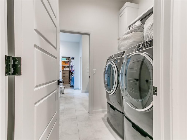3532 Paso Robles Ter, Edmond, OK 73034 - laundry room with light tile patterned floors, washer and clothes dryer, baseboards, and cabinet space