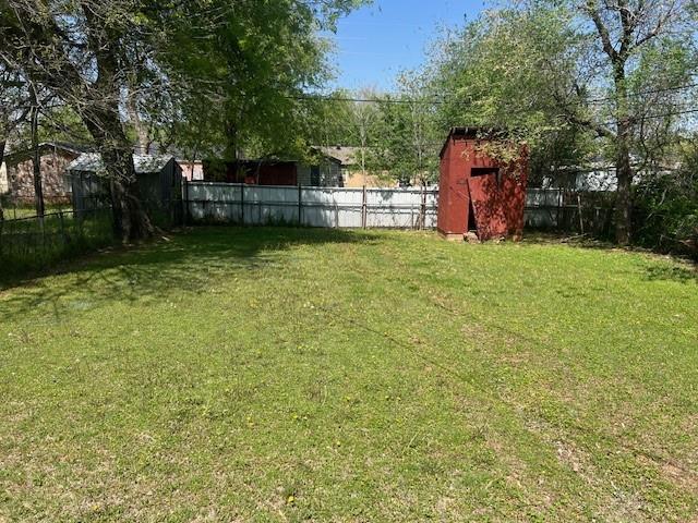 3741 SW 43rd St, Oklahoma City, OK 73119 - view of yard featuring a fenced backyard, a storage unit, and an outdoor structure
