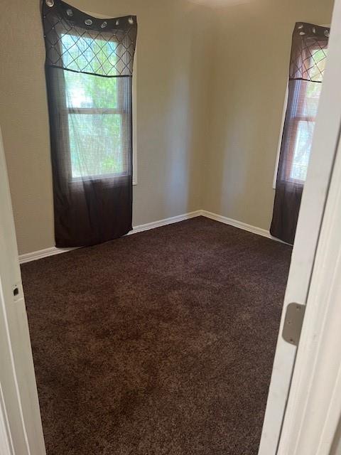 3741 SW 43rd St, Oklahoma City, OK 73119 - unfurnished room with a wealth of natural light, baseboards, and dark carpet