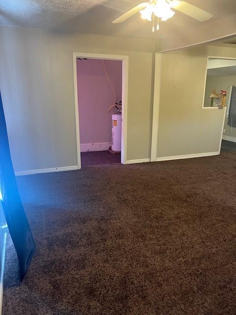 3741 SW 43rd St, Oklahoma City, OK 73119 - unfurnished room with dark carpet, ceiling fan, baseboards, and water heater
