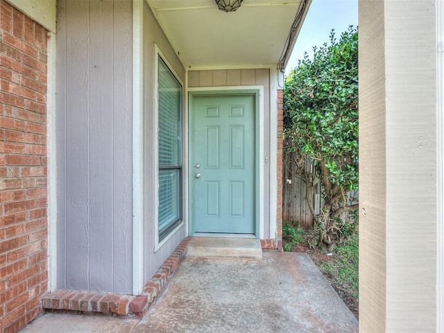 view of exterior entry featuring brick siding