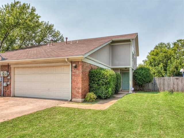 view of front of house with concrete driveway, an attached garage, a front yard, brick siding, and fence