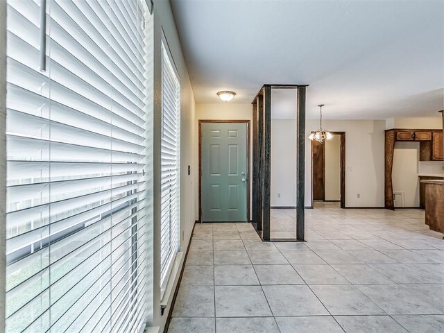 interior space with light tile patterned floors and an inviting chandelier
