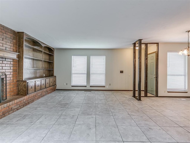 unfurnished living room with built in features, plenty of natural light, and light tile patterned floors
