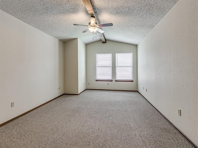 spare room with baseboards, ceiling fan, a textured ceiling, vaulted ceiling, and light colored carpet