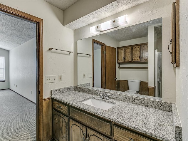 bathroom featuring a textured wall, a textured ceiling, and toilet
