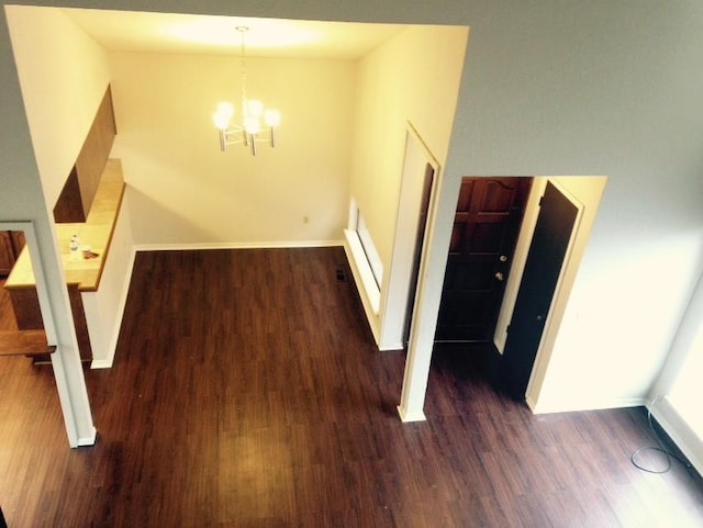 interior space featuring a notable chandelier, baseboards, visible vents, and wood finished floors