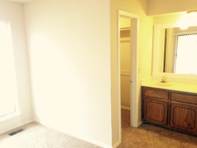 bathroom featuring visible vents, a spacious closet, and vanity