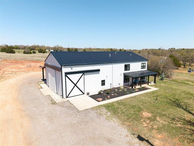 exterior space featuring an outbuilding, metal roof, and a front yard