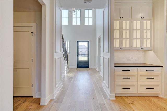 101 Pont Neuf Ct, Edmond, OK 73034 - entrance foyer with a decorative wall, light wood-style flooring, an inviting chandelier, and a high ceiling