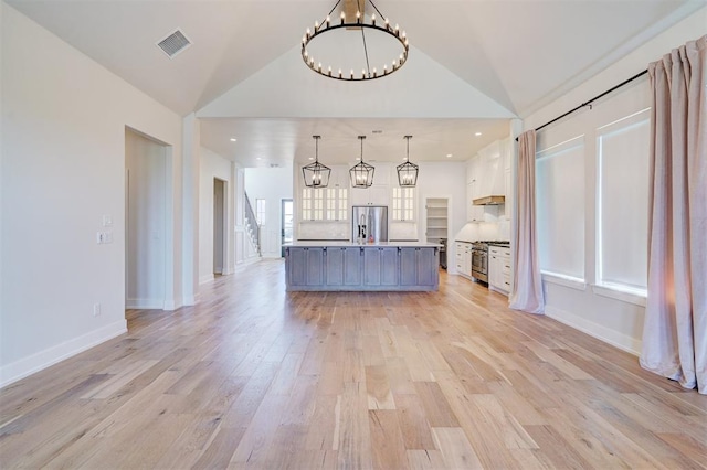 101 Pont Neuf Ct, Edmond, OK 73034 - kitchen featuring white cabinets, visible vents, lofted ceiling, stainless steel appliances, and a notable chandelier