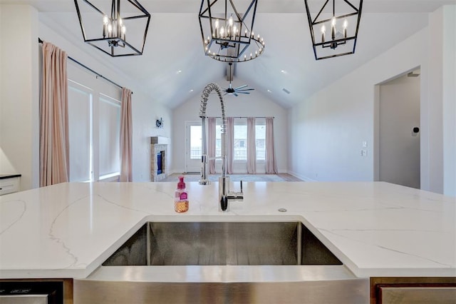 101 Pont Neuf Ct, Edmond, OK 73034 - kitchen featuring open floor plan, an inviting chandelier, light stone countertops, and lofted ceiling