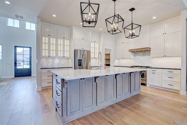101 Pont Neuf Ct, Edmond, OK 73034 - kitchen featuring light wood-type flooring, appliances with stainless steel finishes, an inviting chandelier, and a healthy amount of sunlight