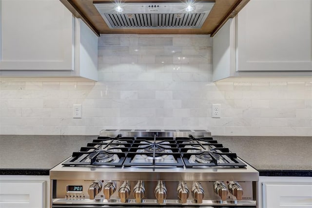 101 Pont Neuf Ct, Edmond, OK 73034 - kitchen with white cabinetry, dark countertops, stainless steel gas stove, and extractor fan