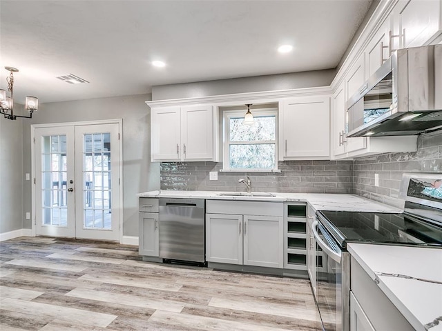 kitchen featuring a sink, decorative backsplash, appliances with stainless steel finishes, and light wood finished floors