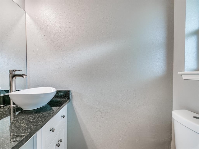 half bath featuring toilet and vanity