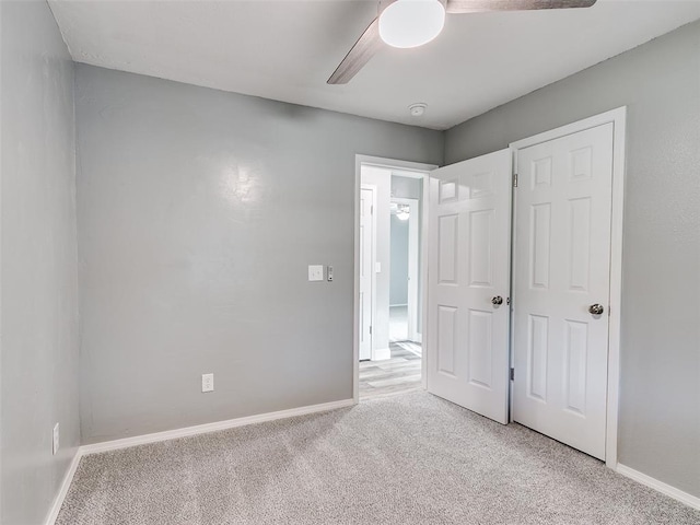 unfurnished bedroom with baseboards, ceiling fan, and light carpet