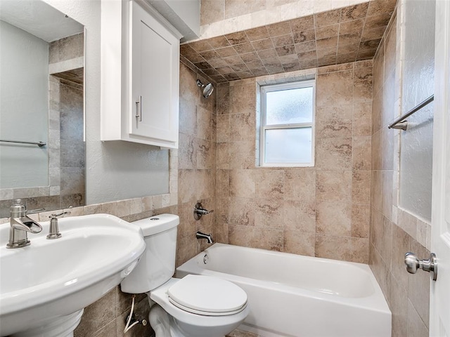full bathroom with shower / bathtub combination, tile walls, a sink, and toilet