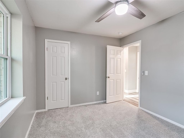 unfurnished bedroom with carpet, baseboards, and a ceiling fan