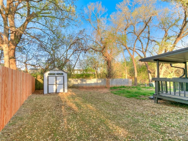 view of yard featuring a shed, a fenced backyard, and an outdoor structure