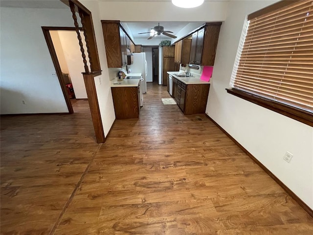 809 Tottingham Rd, Anadarko, OK 73005 - kitchen with dark wood finished floors, dark brown cabinets, a ceiling fan, a sink, and light countertops