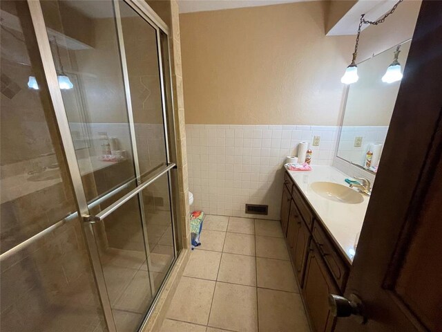 809 Tottingham Rd, Anadarko, OK 73005 - bathroom with a shower stall, vanity, tile patterned flooring, and tile walls