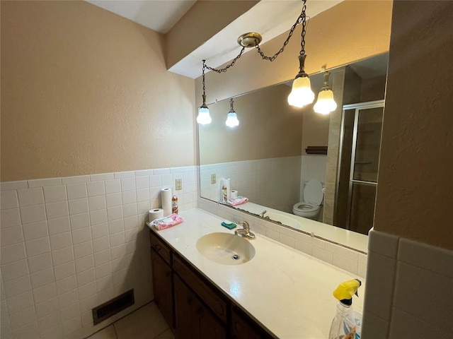 809 Tottingham Rd, Anadarko, OK 73005 - full bath with visible vents, tile walls, wainscoting, vanity, and a stall shower